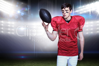 Composite image of american football player playing with the bal