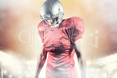 Composite image of american football player looking down while s