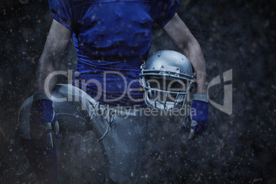 Composite image of mid section of sportsman holding helmet