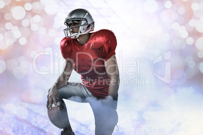 Composite image of sportsman holding american football while kne