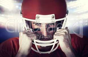 Composite image of portrait of rugby player wit hands on helmet