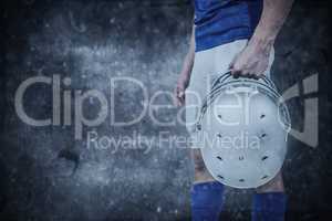 Composite image of sports player handing his helmet