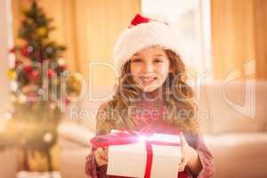 Festive little girl opening a gift