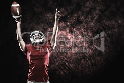 Composite image of american football player with holding ball ar