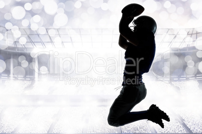 Composite image of silhouette american football player jumping w