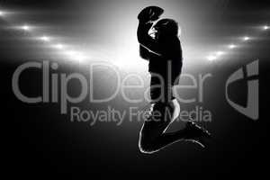 Composite image of silhouette american football player jumping w