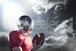 Composite image of sportsman looking at american football while