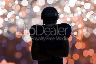 Composite image of silhouette american football player standing