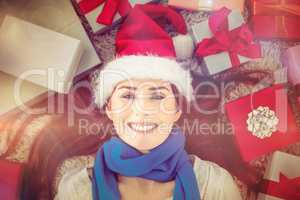 Festive redhead smiling at camera with gifts