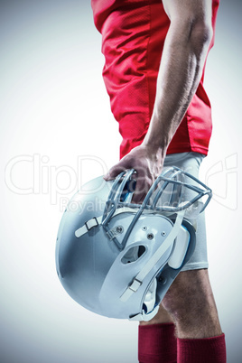 American football player holding helmet