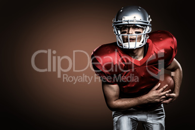 Composite image of american football player holding ball