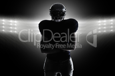 Composite image of silhouette american football player standing