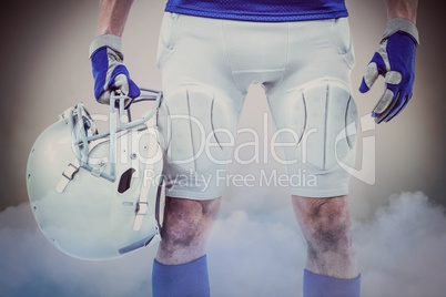 Composite image of midsection of american football player holdin