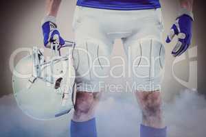 Composite image of midsection of american football player holdin