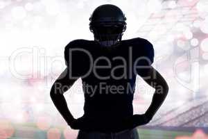 Composite image of silhouette american football player standing