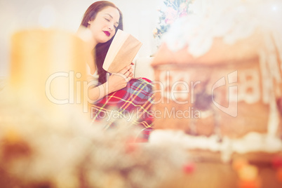 Peaceful brunette reading on the couch with cover