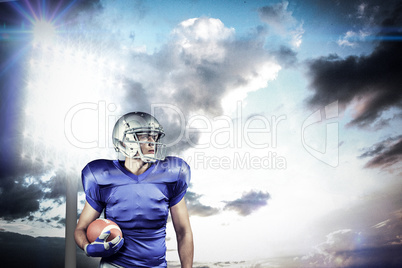 Composite image of confident american football player looking aw