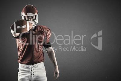 Composite image of portrait of american football player showing football to camera