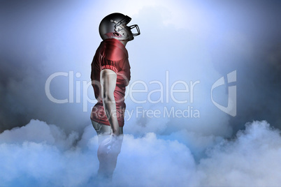 Composite image of american football player looking up while sta