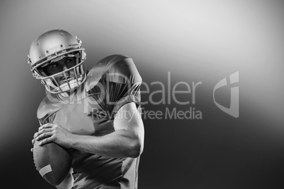 American football player in red jersey looking away while holdin