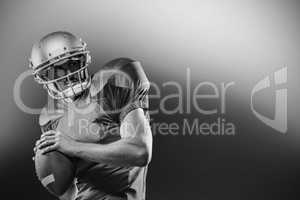 American football player in red jersey looking away while holdin