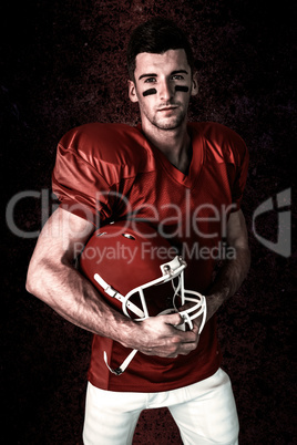 Composite image of portrait of rugby player posing with helmet