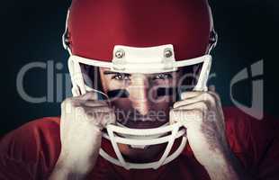 Composite image of portrait of rugby player wit hands on helmet