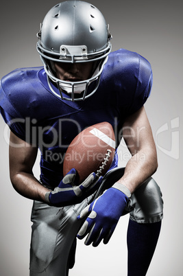 Composite image of american football player holding ball while k