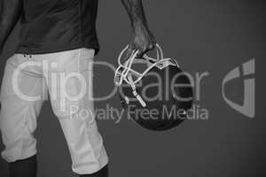 Composite image of midsection of player holding rugby helmet
