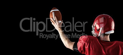 Composite image of rear view of american football player holding Composite image of rear view of american football player holding