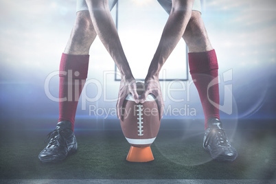 Composite image of low section of sports player placing the ball