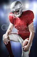 Composite image of american football player with hand on knee
