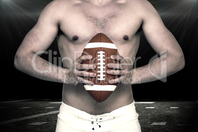 Composite image of shirtless american football player holding a