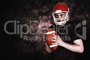 Composite image of serious american football player holding a ba
