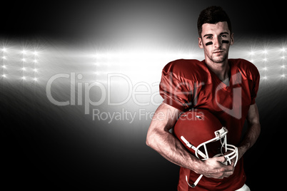 Composite image of portrait of rugby player posing with helmet