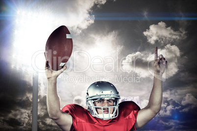 Composite image of american football player with arms raised hol