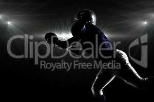 Composite image of silhouette american football player catching