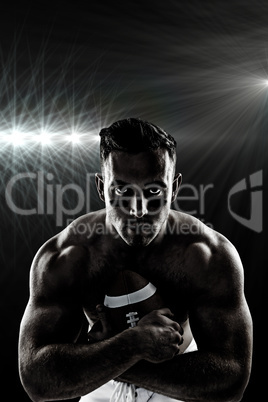 Composite image of shirtless american football player with ball