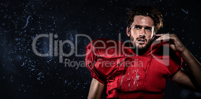 Composite image of wet american football player in red jersey lo