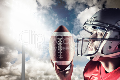 Composite image of sportsman looking up while holding american f