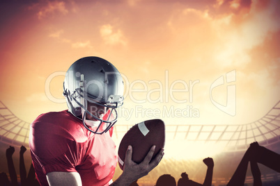 Composite image of sportsman looking at american football while