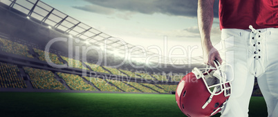 Composite image of front view of american football player holdin