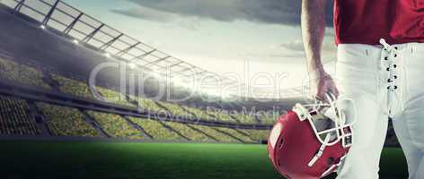 Composite image of front view of american football player holdin