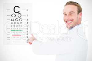 Composite image of smiling optician pointing eye test