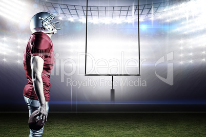 Composite image of american football player looking up while sta