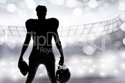 Composite image of silhouette american football player holding b
