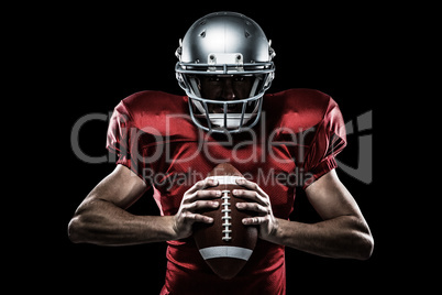 Composite image of american football player in red jersey and helmet holding ball