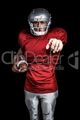 Composite image of portrait of confident sportsman pointing whil