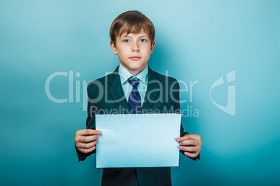 European appearance teenager boy in a business suit holding a wh