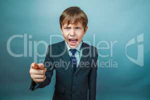 European appearance teenager boy in a business suit points a fin